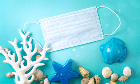 Beach Summer layout with medical mask on blue background. Concept of travel and vacation, Summer new normal. High quality photoの写真素材