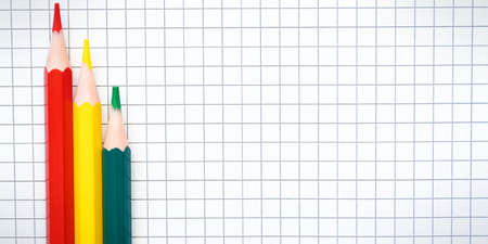 Three red yellow Blue pencils on the blank checkered page. High quality photoの写真素材