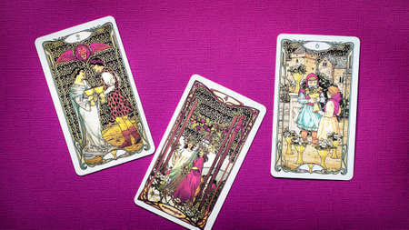 Moscow, Russia - July 2021: View of Golden tarot cards the four of wands, two of cups, six of cups...