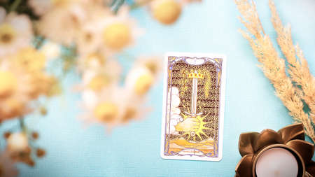 Moscow, Russia - JuLy 2021: Summer composition with Tarot cards ace of swords and flowers on the Blue background, esoteric concept, fortune telling and predictions. High quality photoのeditorial素材