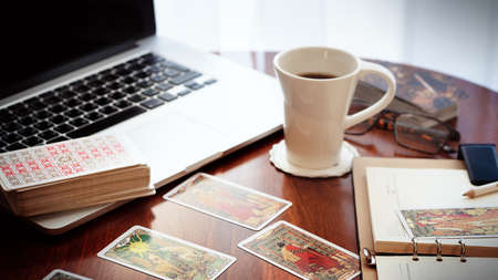 Tarot card reader arranges cards in a card spread. Fortune-telling on traditional tarot cards on the table. Selective focus, Moscow, Russia-June 2021.のeditorial素材