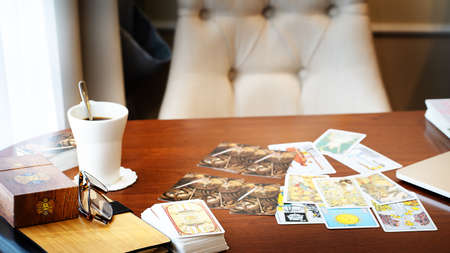Tarot card reader arranges cards in a card spread. Fortune-telling on traditional tarot cards on the table. Selective focus, Moscow, Russia-June 2021.のeditorial素材
