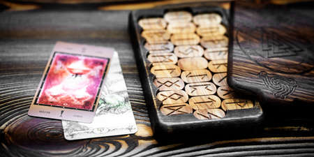 Blurred runes in a wooden carved box on the table. Future reading and esoteric concept. Magic...