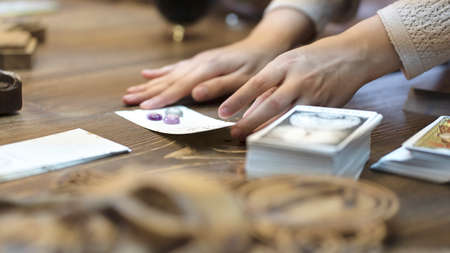 Tarot card reader arranges cards in a card spread. Fortune-telling on traditional tarot cards on the...