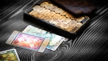 Blurred runes in a wooden carved box on the table. Future reading and esoteric concept. Magic...