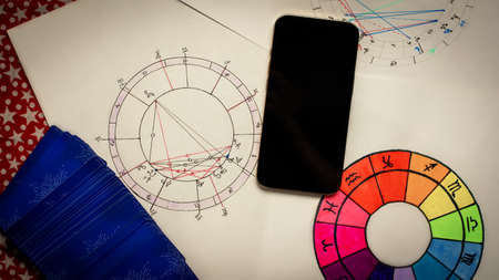 Cartomancy and fortune telling concept. Natal chart smartphone with White screen tarot cards. high quality photoのeditorial素材
