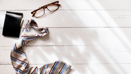 Top view photo of stylish striped necktie, wallet and glasses on white wooden background with copy space. high quality photoの写真素材