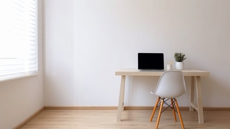Laptop on a desk in a room with white walls and wooden floorの素材