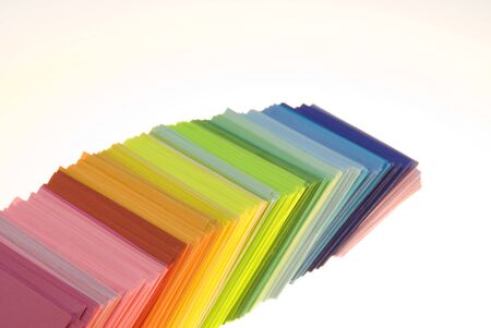 Various color shits of paper scattered on white background