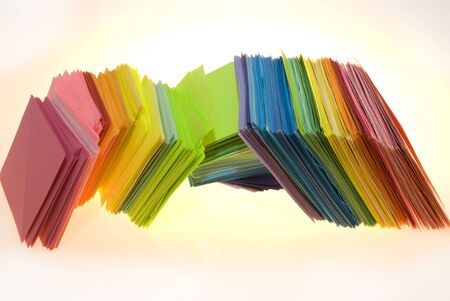 Various color shits of paper scattered on white backgroundの写真素材