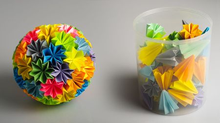 Colorfull origami kusudama from rainbow flowers isolated on white. And unit for it on the box.の写真素材