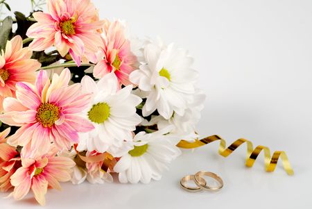 Pink  and white daisy with gold ribbon and wedding rings. Still life isolated on whiteの写真素材