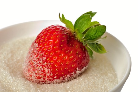 One strawberry in bowl with sugar isolaed on white の写真素材