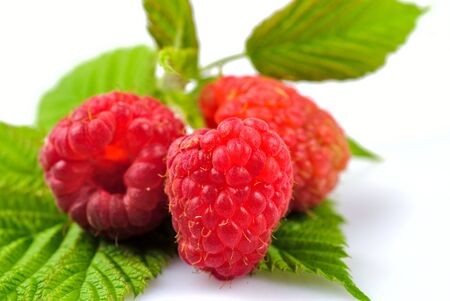 Raspberries with green leafs isolated on white background