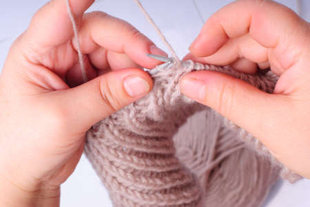 Knitting hands close up with woven thread