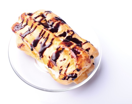 Eclair on plate isolated on white background