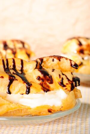 chocolate eclairs in plate on table close up