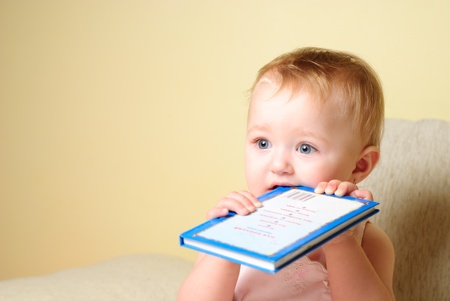 Little girl are reading the book, sitting on the sofaの写真素材