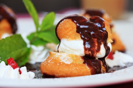 profiteroles with ice cream chocolate on plateの写真素材