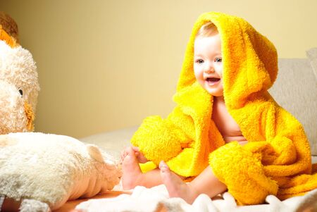 Girl after bathing, sitting in yellow bathrobeの写真素材