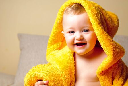 Girl after bathing, sitting in yellow bathrobeの写真素材