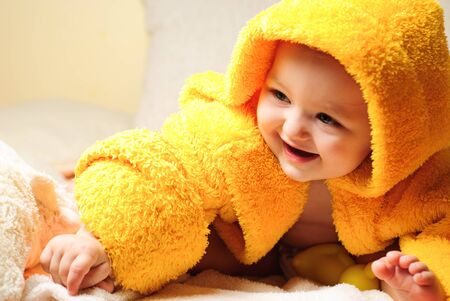 Girl after bathing, sitting in yellow bathrobeの写真素材