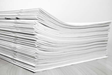 Stack of white journals on table, closeup part in black and white