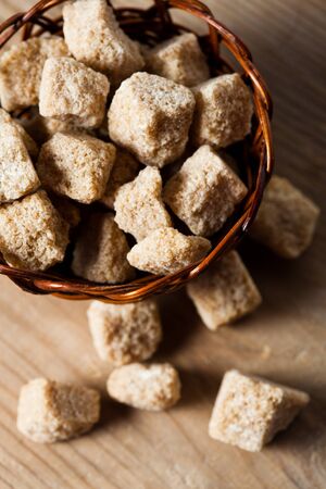 Brown sugar, natural cubes closeup in basketの写真素材