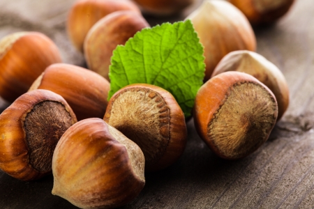 Hazelnuts with shell and green leaf on the wooden tableの写真素材