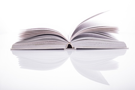 One open white book with reflection on whiteの写真素材