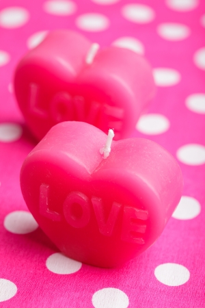 Red scented candle in the shape of heart closeup on the pink backgroundの写真素材