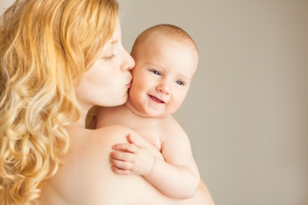 A natural blonde caucasian mother kissing happy babyの写真素材