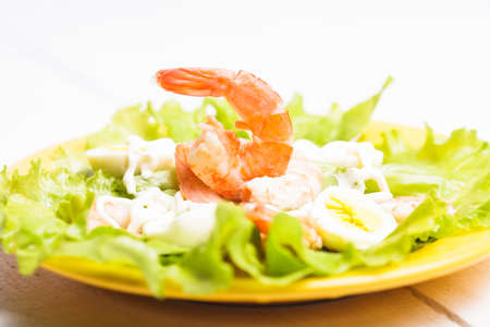 Salad with boiled shrimps, quail eggs and sauceの写真素材