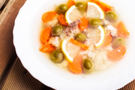 Sturgeon with lemon and carrot slices and green olives in aspic