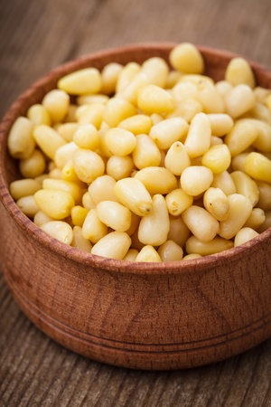 Pine nuts in a wooden bowl close upの写真素材