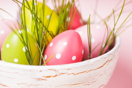 Decorative eggs in pot with grass over pink background. Easter decor.の写真素材