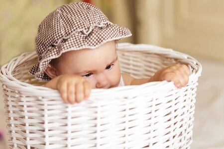 Eight month baby girl play with laundry basketの写真素材