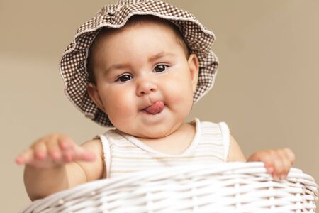 Eight month baby girl play with laundry basket