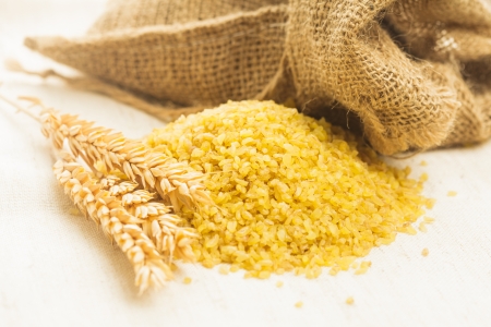 Raw bulgur heap on the linen textileの写真素材