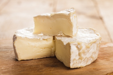 camembert cheese section on the wooden board. Macro imageの写真素材