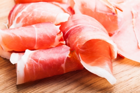 prosciutto slices close up on the wooden tableの写真素材