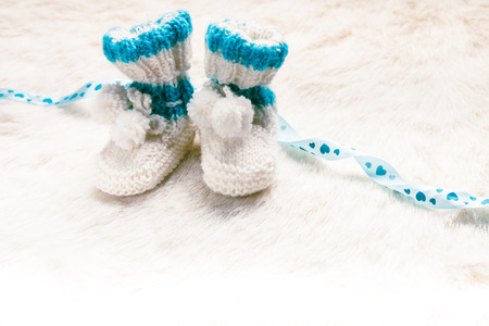 Knitted blue baby booties for little boy with copy spaceの写真素材