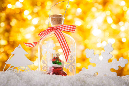 Christmas decor on the snow with gold bokeh backgroundの写真素材