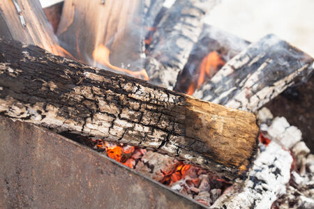 Burning firewood in grill for barbecue close upの写真素材