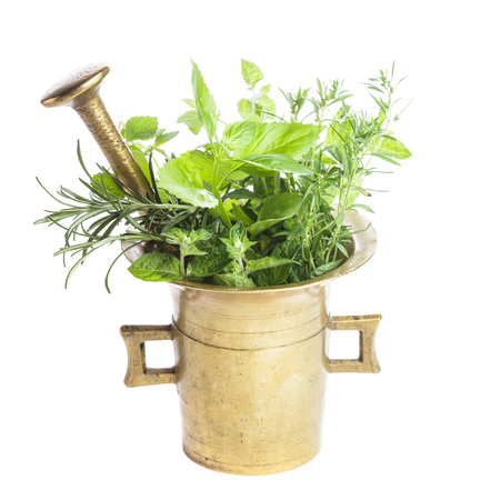 Fresh herbs in the copper mortar on the tableの写真素材
