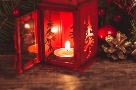 Red christmas candlestick over holiday decorations on the tableの写真素材