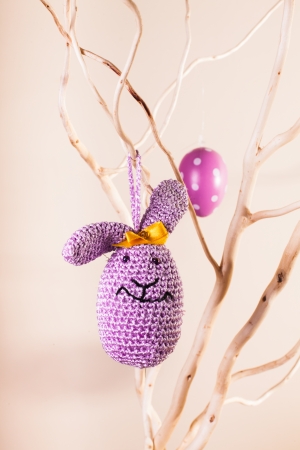Handmade crochet easter decorations on the branches - bunny eggの写真素材
