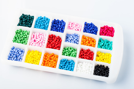 Various colors beads on the white plastic box close upの写真素材