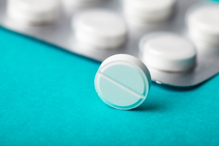 One tablet closeup on background with pack of pillの写真素材