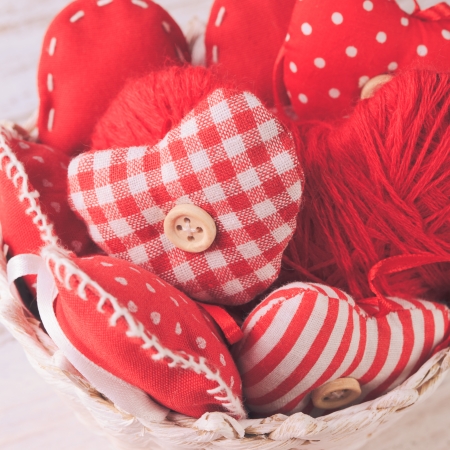 Valentine decorations: textile red hearts in white basket on the shabby tableの写真素材